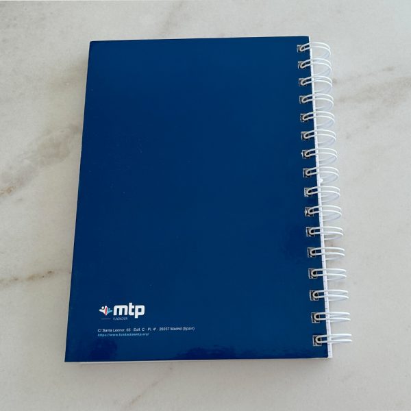 Cara posterior de libreta de anillas con logo de Fundación MTP sobre fondo azul oscuro.